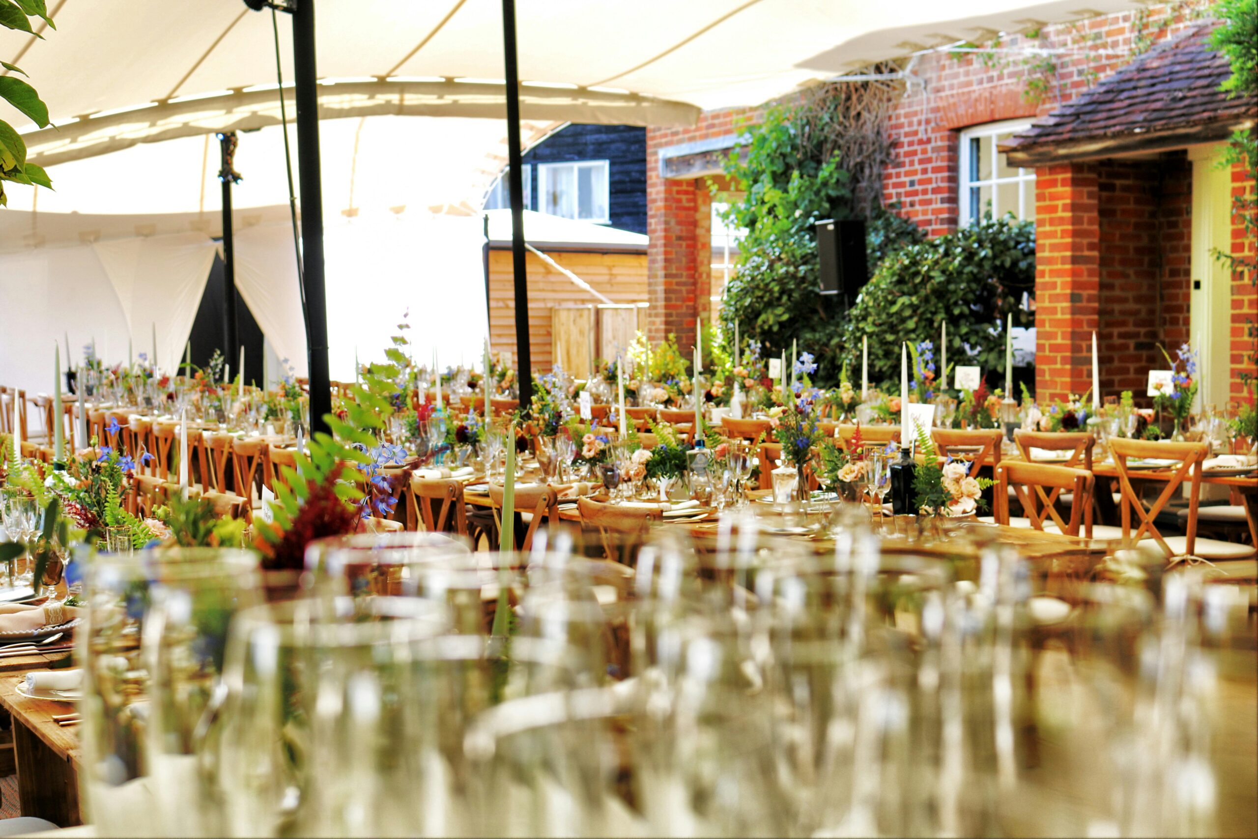 Charming outdoor dining setting with flowers and fine tableware creating an inviting atmosphere.